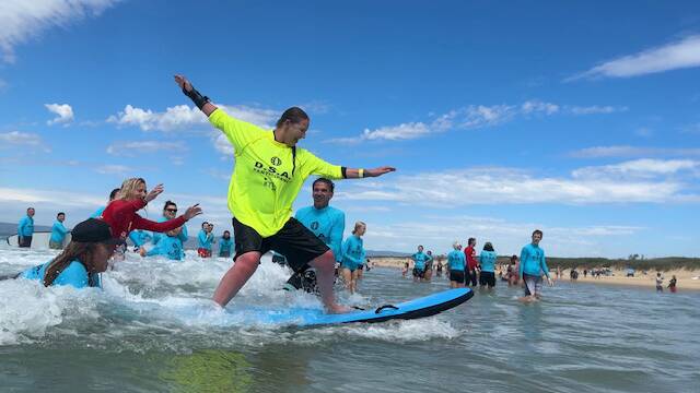 Disabled surfers ride the waves at Port Kembla beach. Picture supplied by Glenn Fenwick