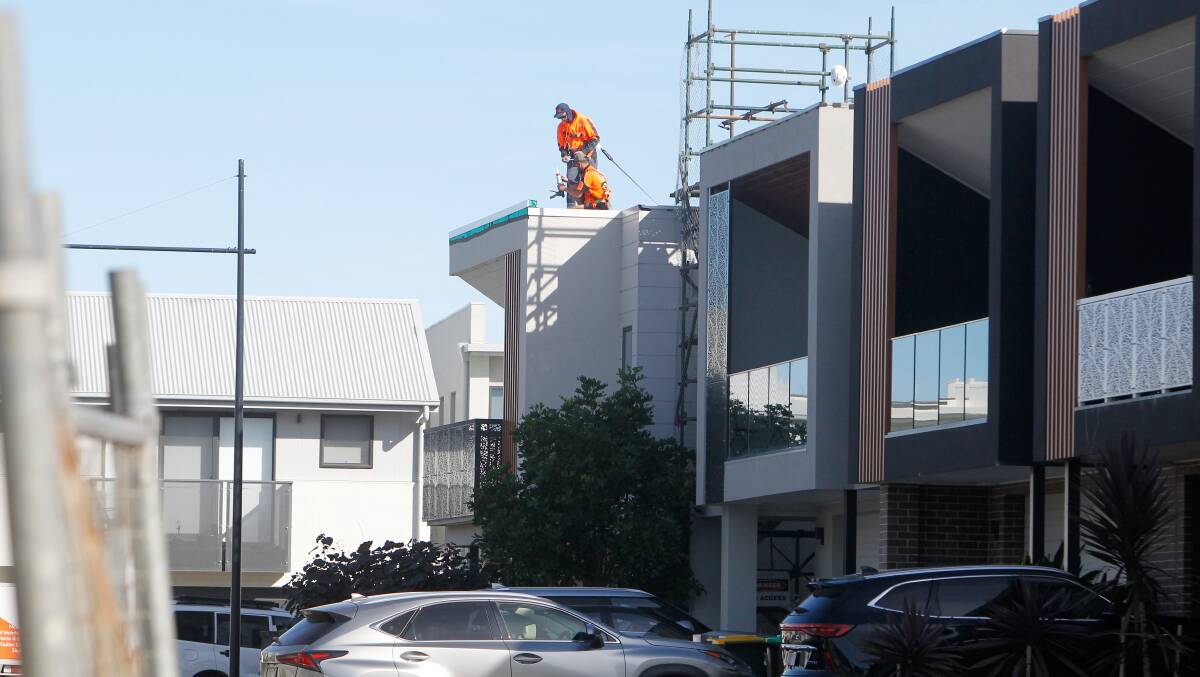 Workers fix leaky roofs on home in The Waterfront, Shell Cove. Picture by Sylvia Liber