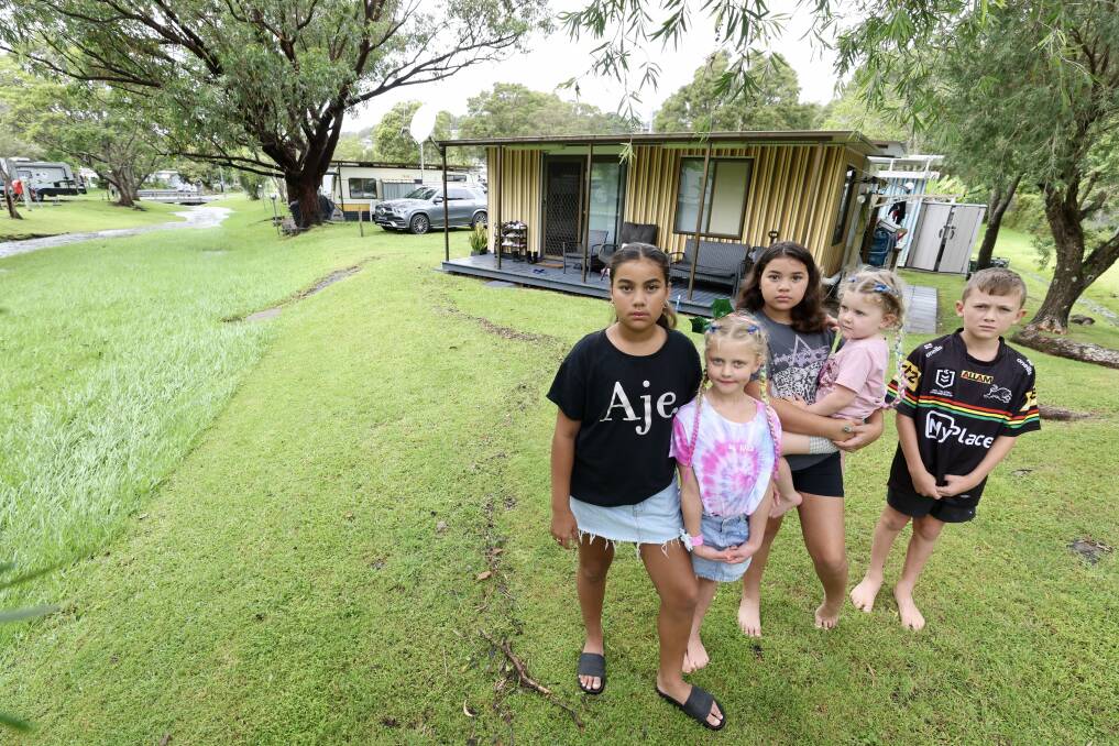 Zara, 11, Grace, 6, Hallie, 9, Ivy, 3, and Connor, 9, showing where the water came up to outside their cabin at BIG4 Easts Beach Holiday Park Kiama on December 26. Picture by Adam McLean