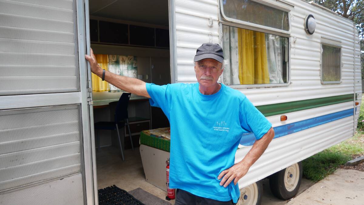 Michael Brosnan stands outside one of the Social Justice Advocate's caravans that will need to be removed for the summer holiday season. Photo: Ellouise Bailey