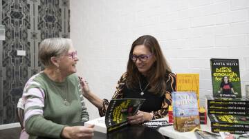 TEN YEARS ON: Wiradyuri woman and author Anita Heiss signs a copy of her book 'Am I Black Enough For You?' for Jan Roberts at the Curious Rabbit on Sunday. Picture: Madeline Begley