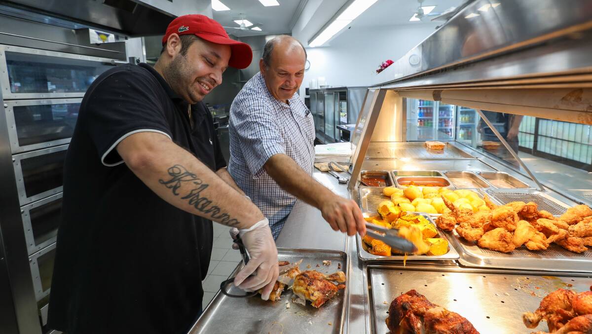 Tony Gregoriou, right, with employee Amit Khanna at Tony's Chicken Shop. Picture: Adam McLean