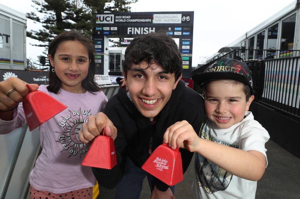 UCI fans Macey Guevara, Theo Suarez-Hoyos, and Xavier Guevara with their cowbells at the finish line at Lang Park. Picture by Robert Peet