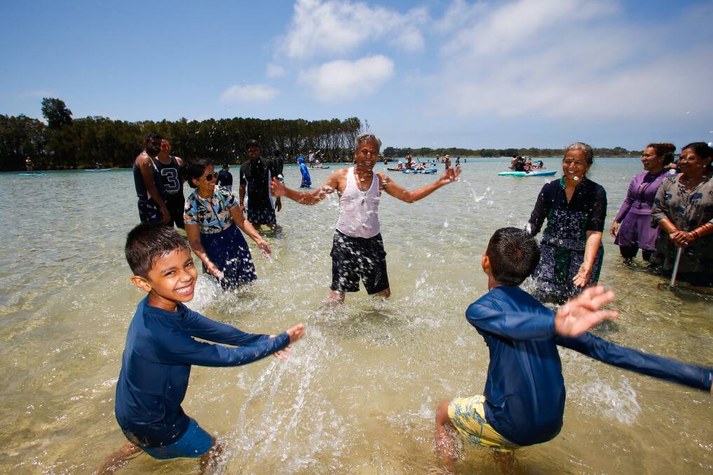 Crowds flocked to the beach for some sunshine on Boxing Day. Dipak Shah from India gets splashed by his grandsons in the water near Reddall Reverve, Warilla. Picture by Anna Warr