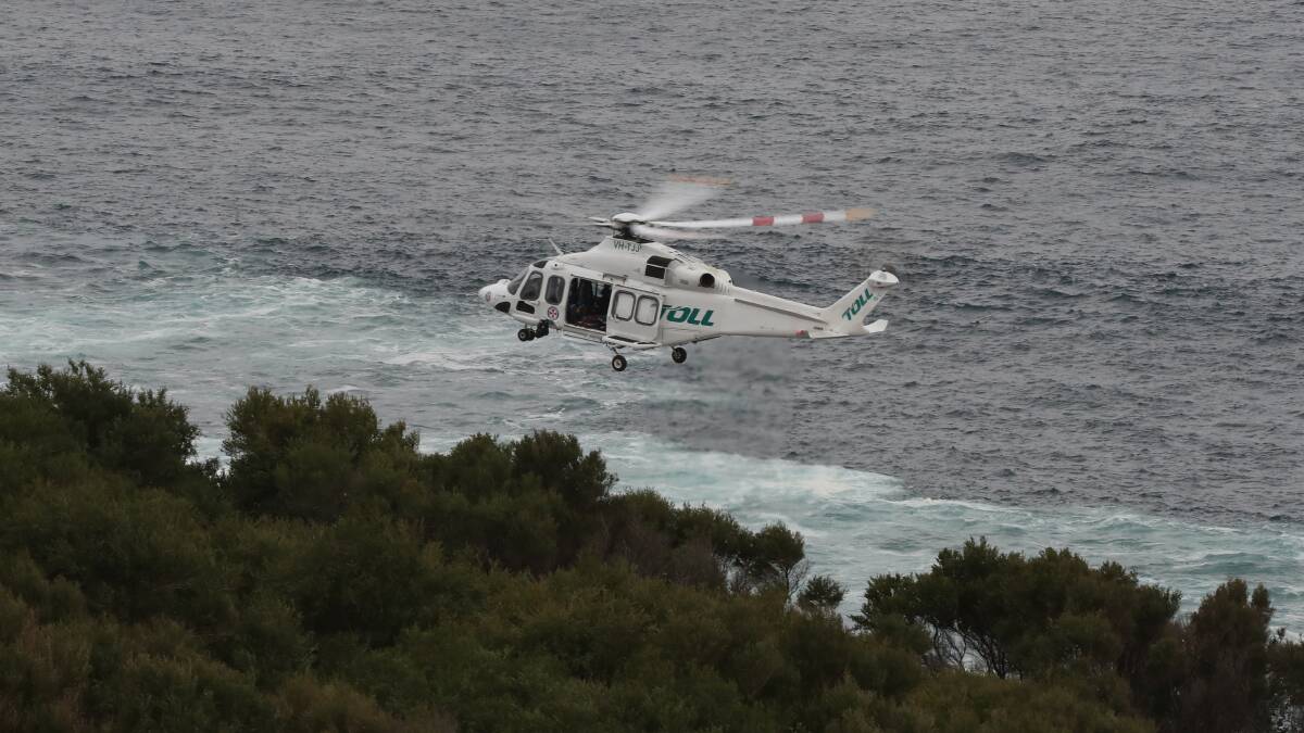 A rescue helicopter searching for the missing fisherman. Picture: Robert Peet