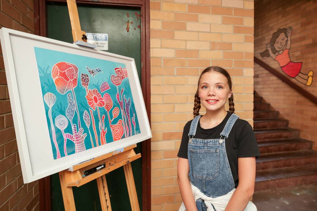 The 11-year-old artist behind the mural Lily Thomson with some of her other artwork. Picture by Adam McLean.