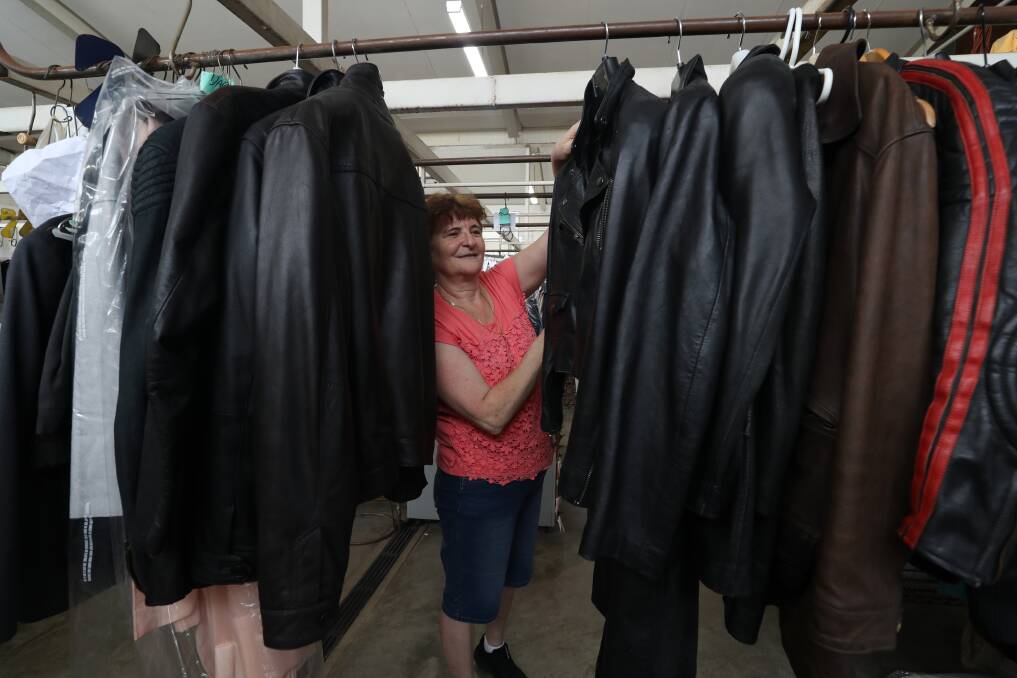 DRY CLEAN: Wollongong drycleaner Stella Martino stands with numerous leather jackets that have been brought in. The business has seen around a 150 per cent increase of mouldy jackets needing attention. Picture: Robert Peet
