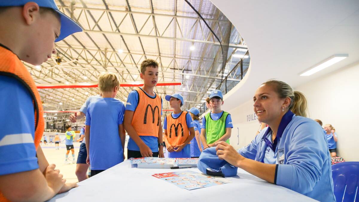 Hawkesby signing gear for young ones at Sydney FC's UOW clinic. Picture by Adam McLean