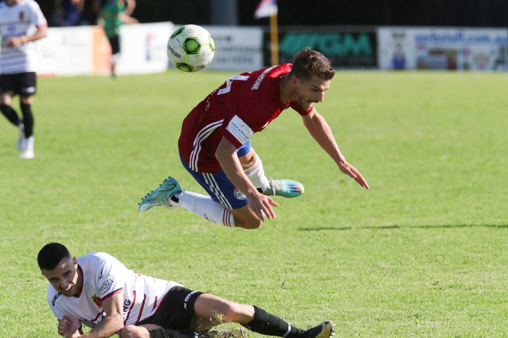 Tory Musemeci goes down from a hefty challenge by Andre Dias in Albion Park's 2-1 win against Cringila. Picture by Sylvia Liber