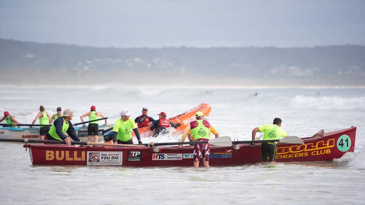 Team Bulli pushing their surf boat out into some rough conditions. Picture by Nick Peters Photography 