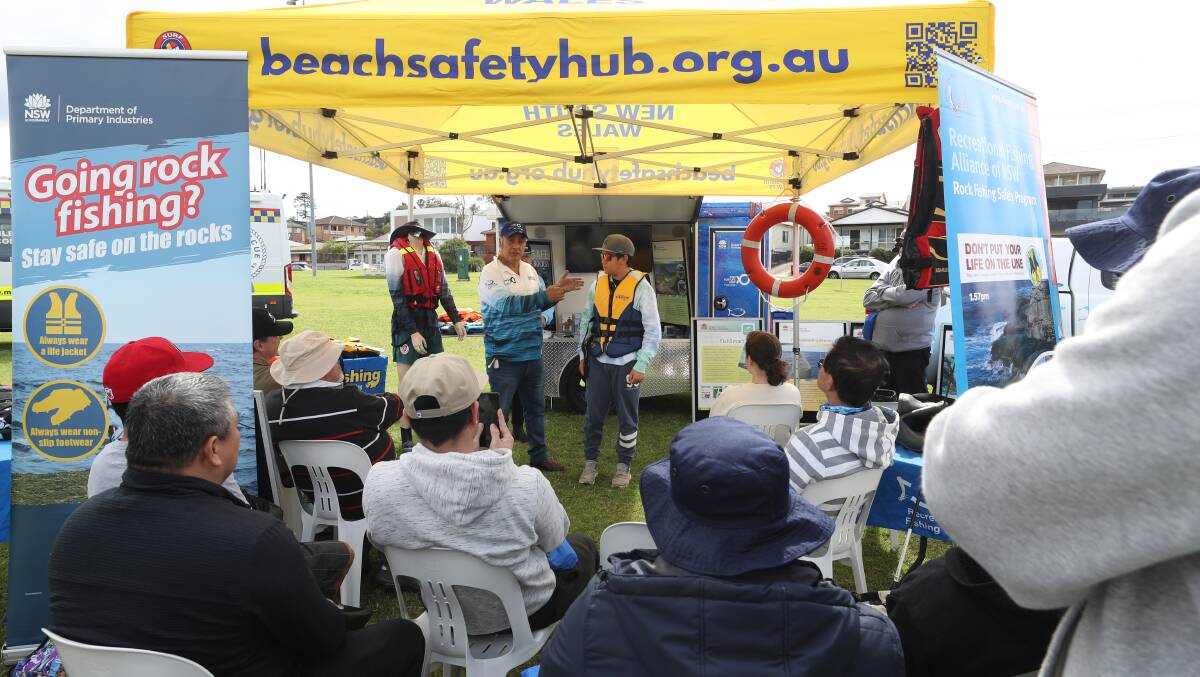 Fisheries community relations manager George Mannah with Mark Halili from Albion Park discussing the importance of lifejackets when rock fishing. Picture by Robert Peet