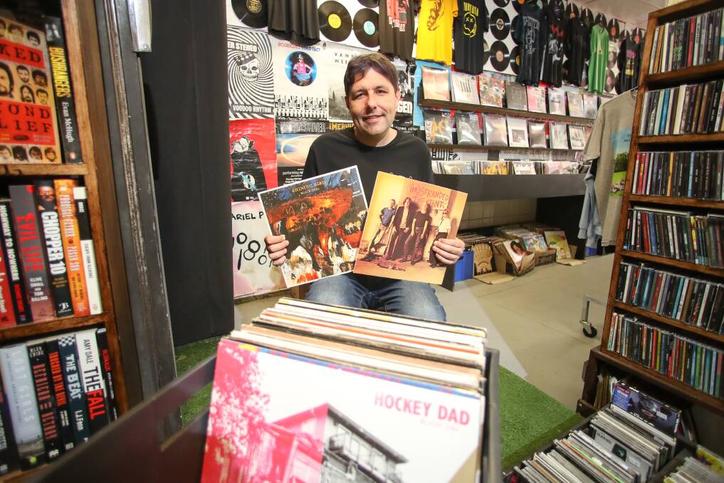 Music Farmers owner Jeb Taylor holding records from Wollongong Band Shining Bird. Picture by Adam McLean