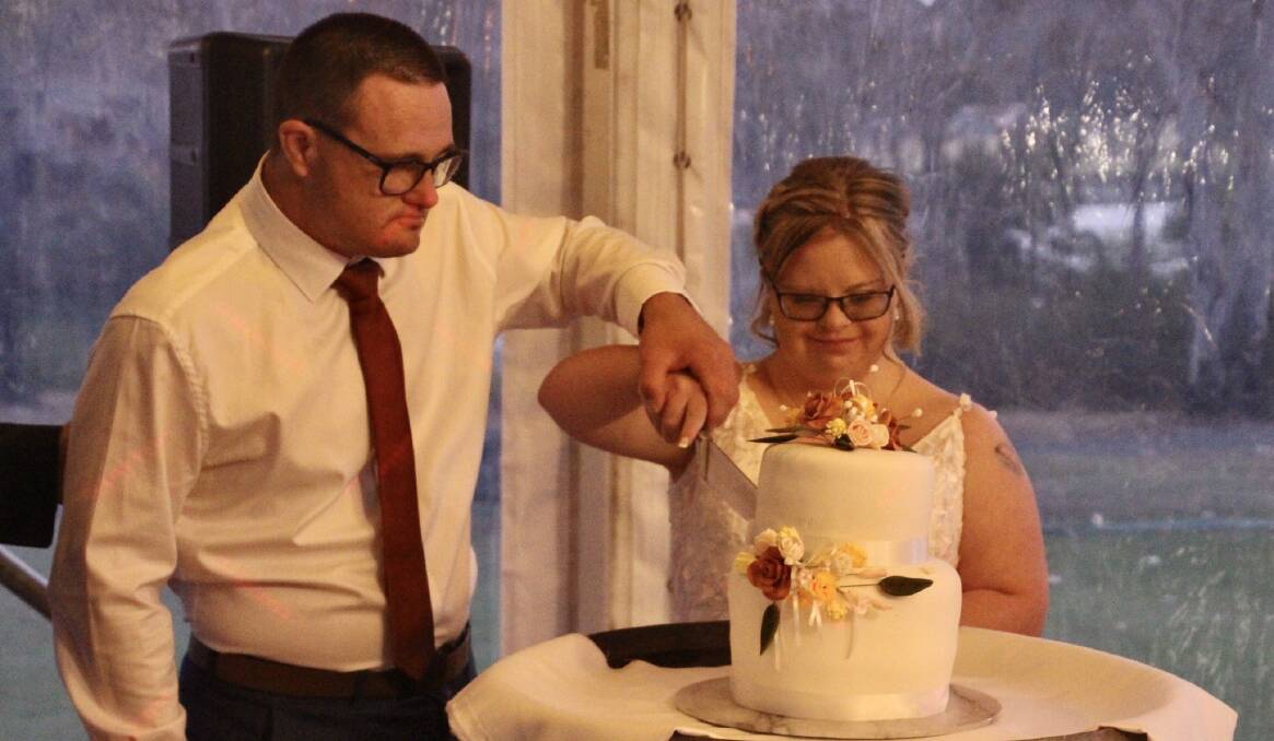 Luke and Samantha cut their wedding cake. Picture supplied.
