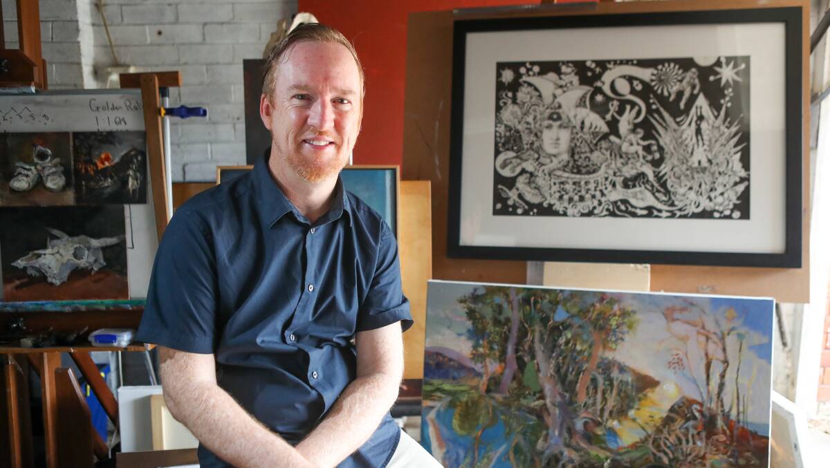 West Wollongong artist John Kennedy at his home studio with his artwork Illumination in top-right. Picture by Adam McLean