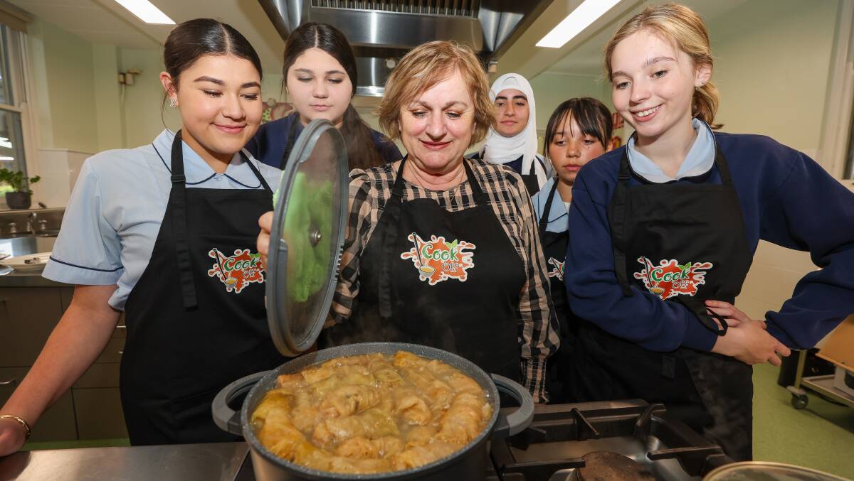 Team Macedonia: MCCI volunteer Anica Petkovski (centre) with Corrimal High School students L-R Talia Duncan, Rebecca Acevski, Raneem Abdulhameed, Isabella Rylewski and Sophie Dickson at the schools' food tech kitchen for the Multicultural Cook-Off. Picture by Adam McLean
