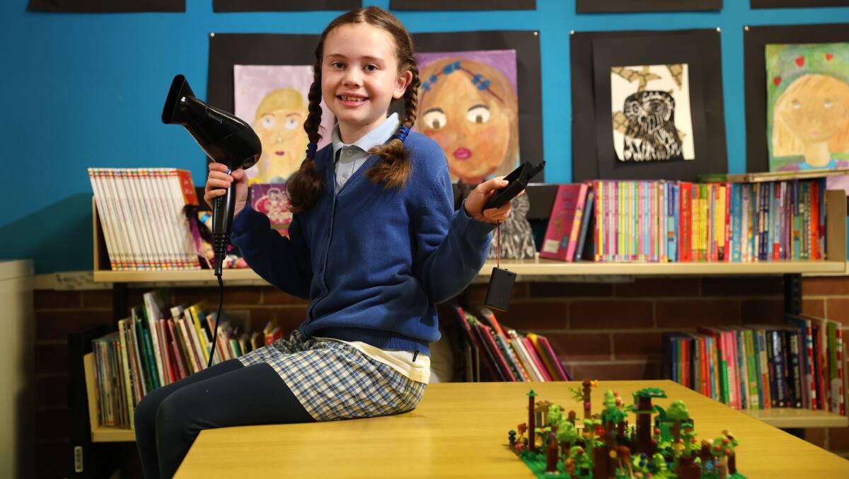 Avalon Jankowski, a student from Tarrawanna Public School holds her 'Wildife Alert' project and a hairdryer (used to replicate a bushfire).Picture by Sylvia Liber
