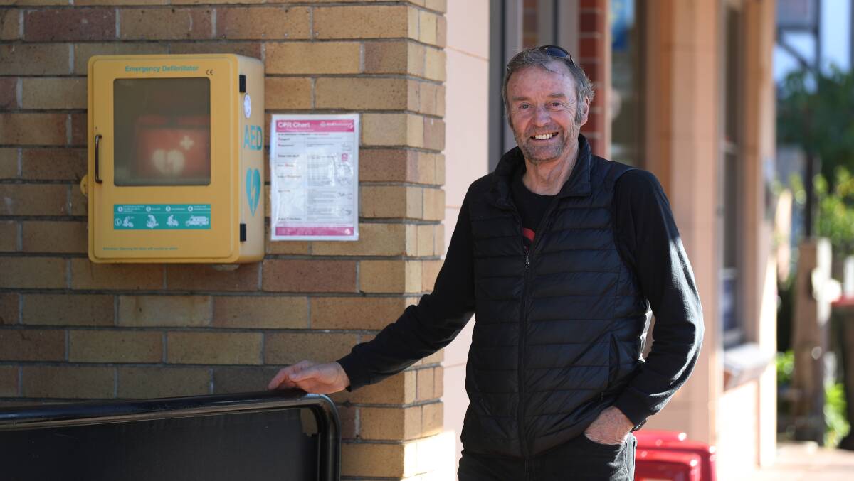 David Toohey stands beside the defibrillator that saved his life in the main street of Jamberoo. Picture by Robert Peet