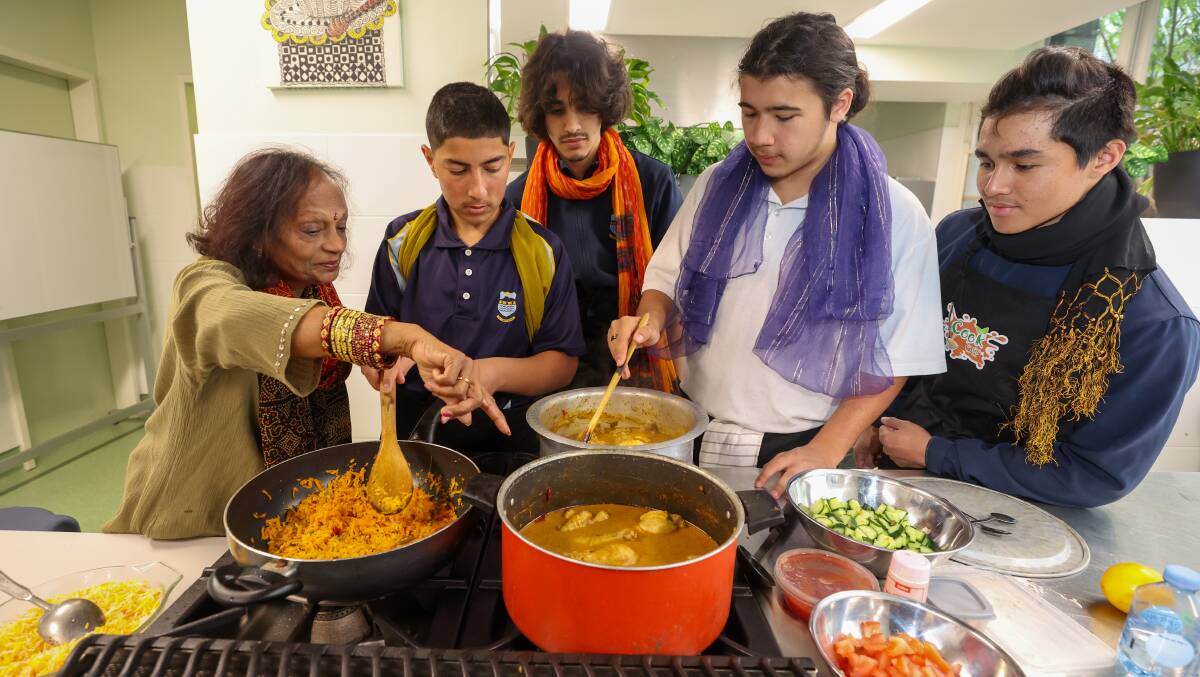 Team India: MCCI volunteer Rebecca Ellis with Corrimal High students L-R Nazhan Mahmoud, Enzo Couto-Fronatdo, Kai Nguyen-Roberts and Ihsan Syafril at the schools' food tech kitchen for the Multicultural Cook-Off. Picture by Adam McLean