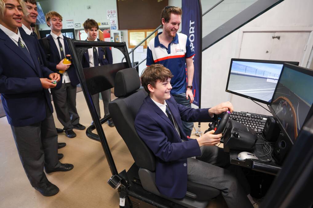 Brandon Shaw from the UOW Motorsport team with St Johns student Mitchell Kelly in the team's racing simulator.