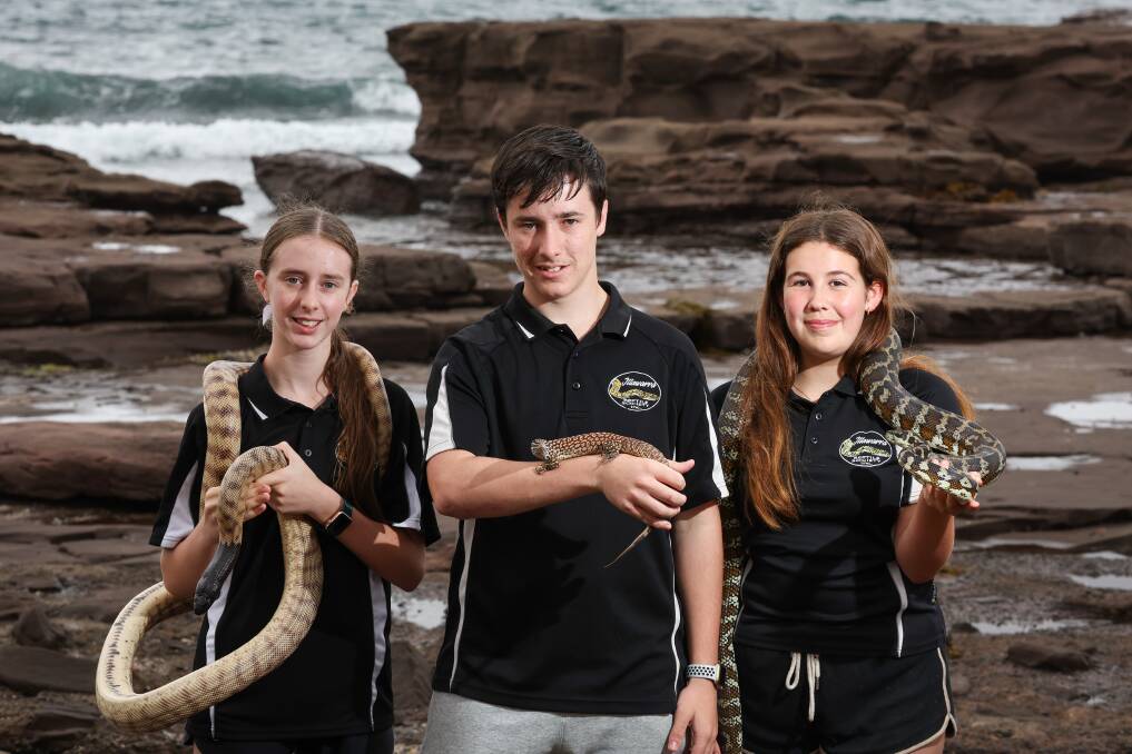Katie Hicks, pictured left, with a black-headed python, Tom Hicks with an Ackie monitor lizard and Ashlee Payne, with a Darwin carpet python, will be at the Illawarra Reptile Show. Picture by Adam McLean