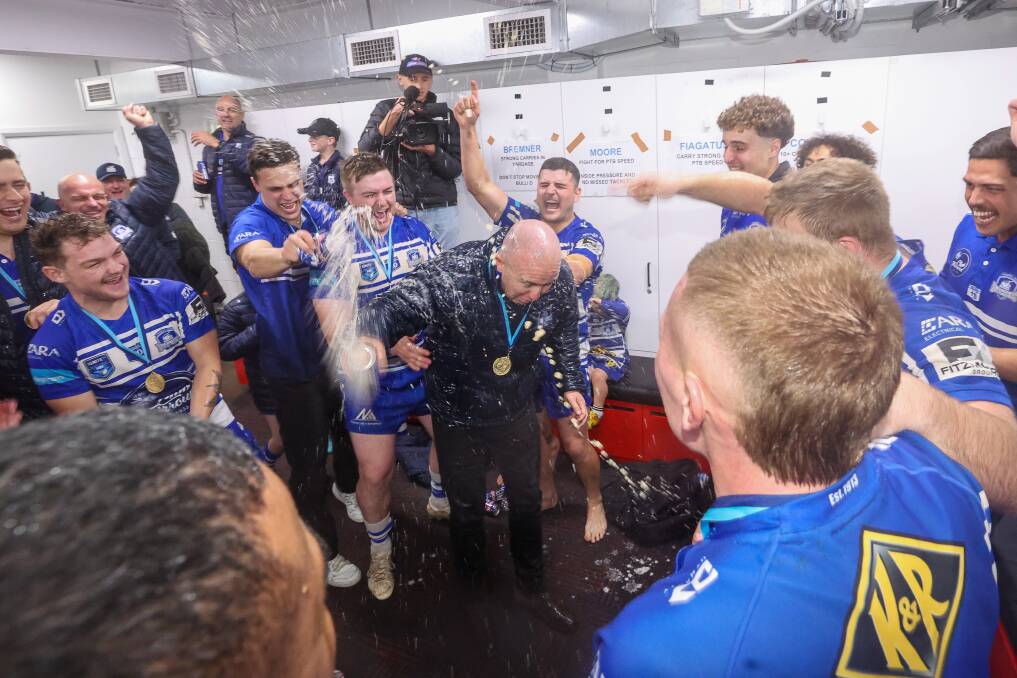 September 2. Thirroul players spray their coach Jarrod Costello in the change room while celebrating their win in the 2023 Illawarra Rugby League grand final against Collegians at WIN Stadium.