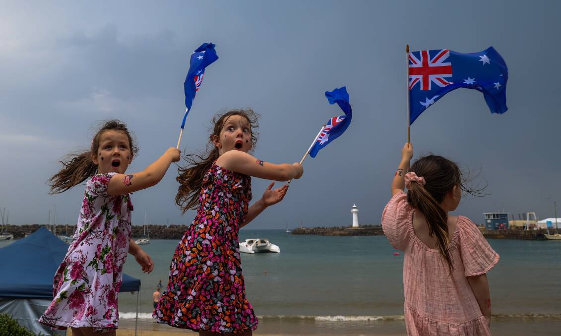 January 26. Matilda, Nova and Aurora Pickering react to wind from an afternoon thunderstorm at Wollongong Harbour on Australia Day. 