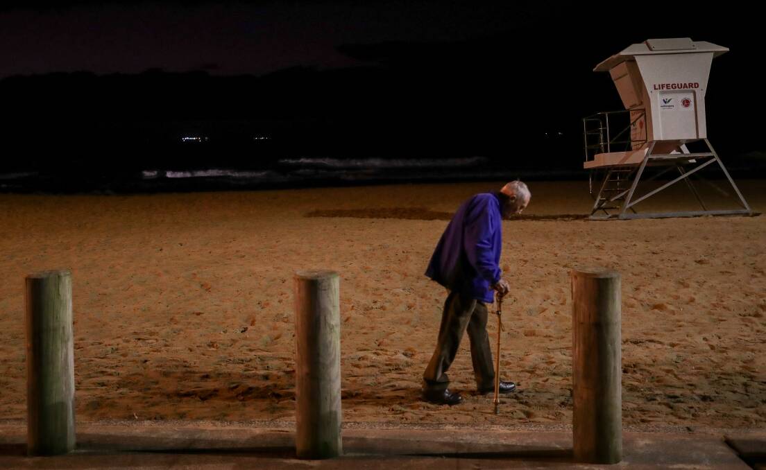 April 25. A man makes his way to the Austinmer Beach War Memorial for the ANZAC Day dawn service. 