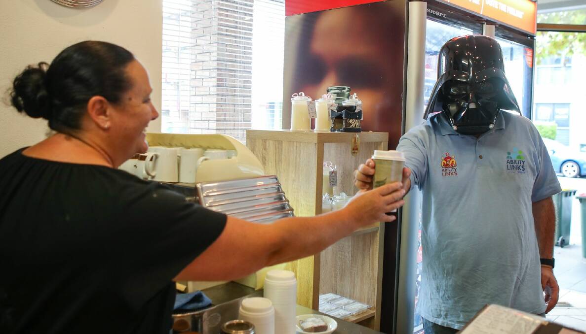 Aaron Clarke at Wollongong's Stew's Coffee Bar wearing a Darth Vader mask in a light-hearted message about wearing masks. Aaron works for Ability Links, an organisation distributing information to businesses about sanitation regarding the COVID-19 outbreak. Picture: Adam McLean