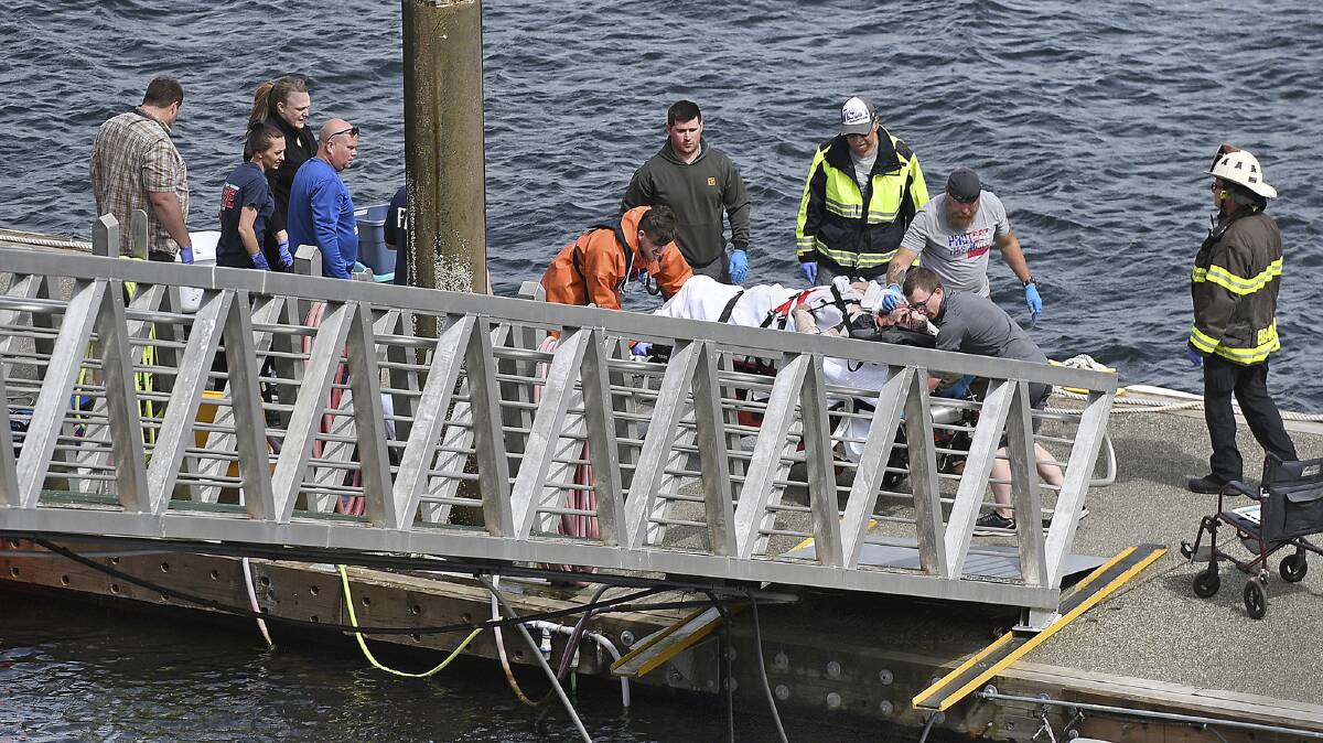Emergency response crews transport an injured passenger to an ambulance at the George Inlet Lodge docks. Picture: Ketchikan Daily News via AP