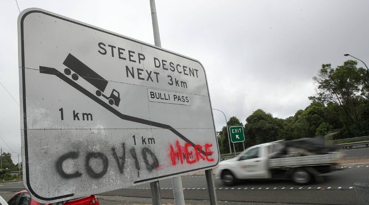 Graffiti on a Bulli Pass sign. Other makeshift signs were put up near beaches to warn non-residents to stay away. Picture Adam McLean