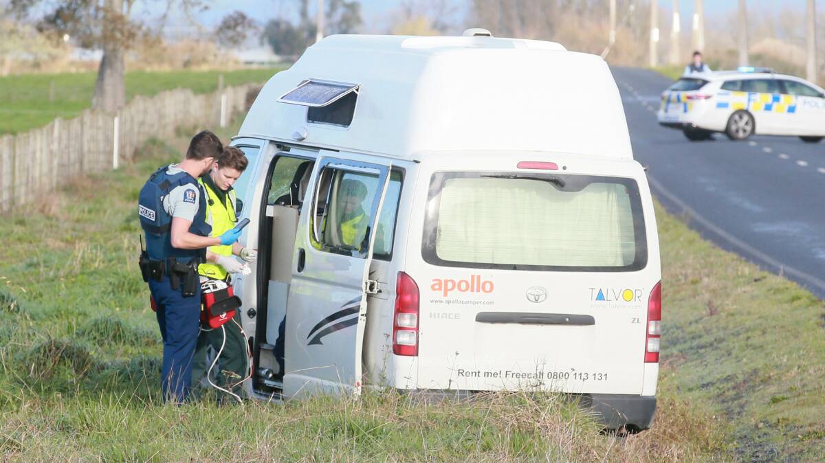 An officer and paramedic work through the open door of the campervan where the body of a man was found on Friday morning. Picture: Mark Taylor/Stuff