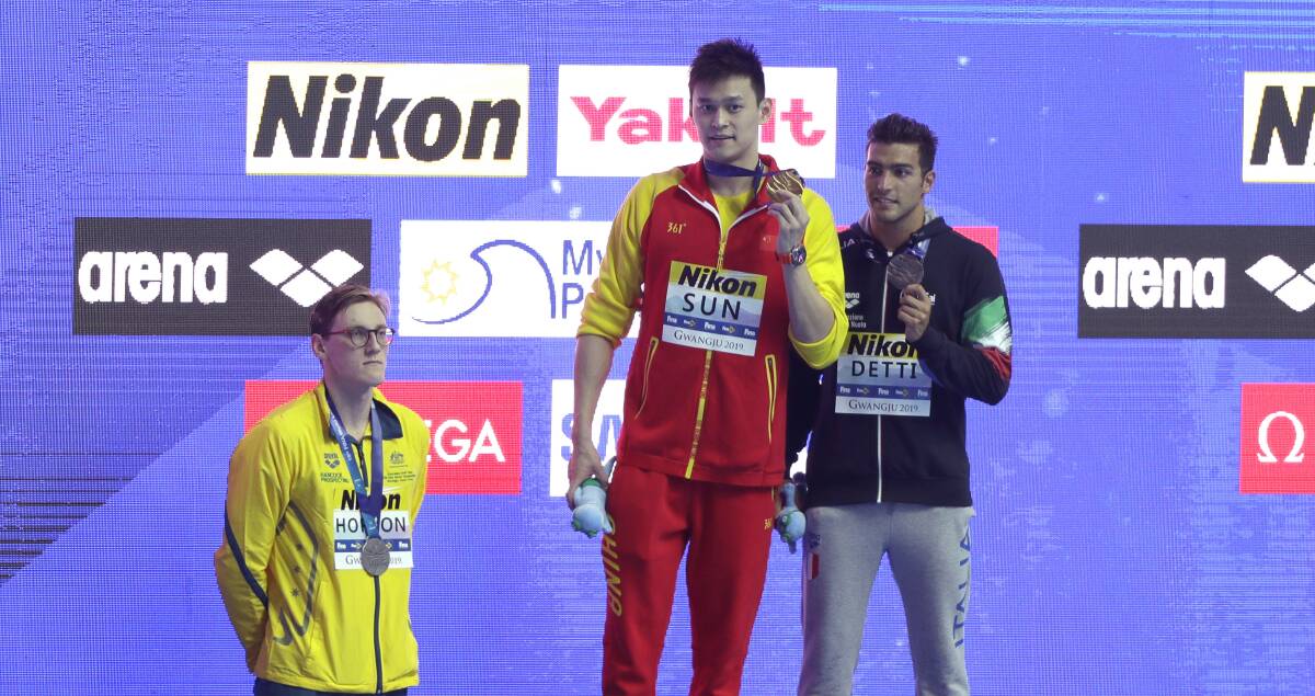 China's Sun Yang, centre, holds up his gold medal as silver medalist Australia's Mack Horton, left, stands away from the podium with bronze medalist Italy's Gabriele Detti right, after the men's 400m freestyle final at the World Swimming Championship Picture: AP