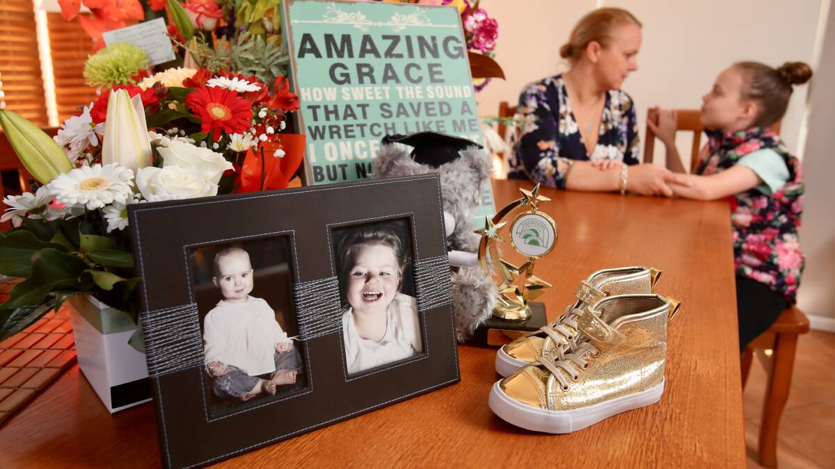 Gracie's mother Susan Wallis and sister Sophie reflect on her life with her famous golden boots, a picture of the two girls when they were younger, the Student of the Year Award trophy from Para Meadows School, a graduation bear present from the midwives who saved her life when she was born and the words of Amazing Grace that hung on her bedroom wall. Picture: Adam McLean.