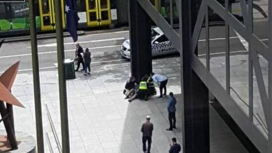 Police treating a person in Melbourne's CBD. Photo: Twitter