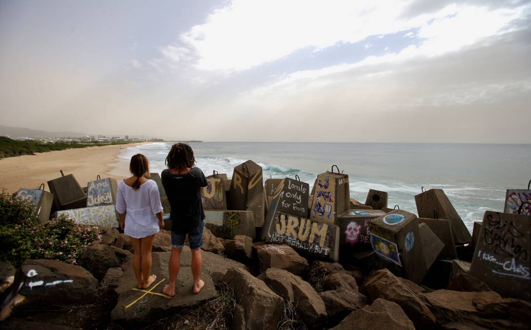 Scott Fuller and Natalie Beekmann look at a dust cloud that settled over Wollongong Thursday morning. Picture: Adam McLean