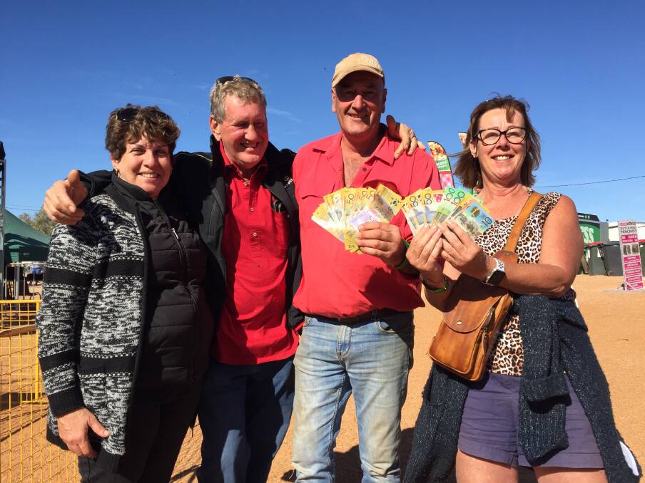 Maryann and Tom Johnson, Innisfail, Grant and Helen Little, Tasmania, get lucky on the pigs at Bedourie Camel Races.