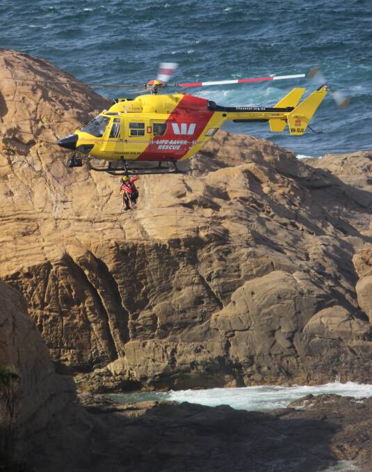 Westpac Life Saver Rescue Helicopter winches four children to safety at Bermagui on Tuesday afternoon. Picture: Chris Richard-Preston