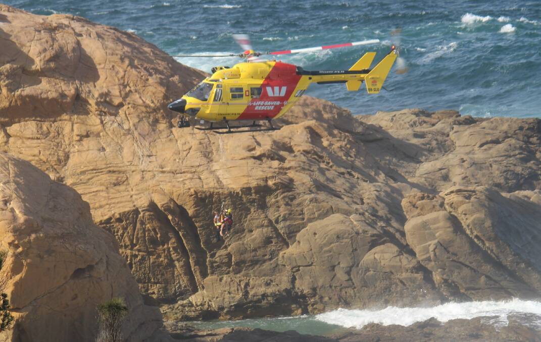 Westpac Life Saver Rescue Helicopter winches four children to safety at Bermagui on Tuesday afternoon. Picture: Chris Richard-Preston