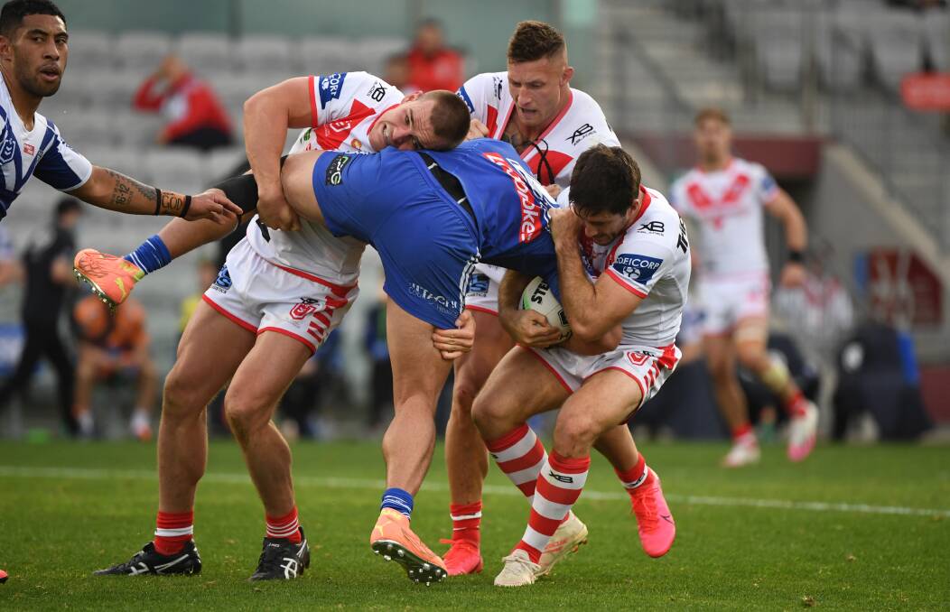 Jackson Ford, Tariq Sims and Ben Hunt tackle a Bulldogs opponent. Photo: NRL Imagery
