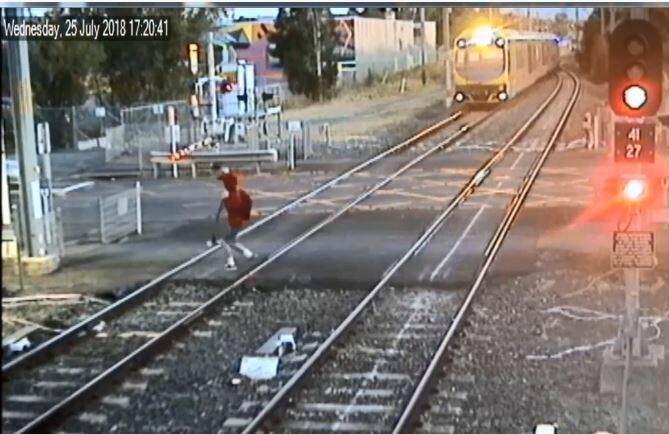A boy runs across the level crossing at Dapto - police are investigating the incident.