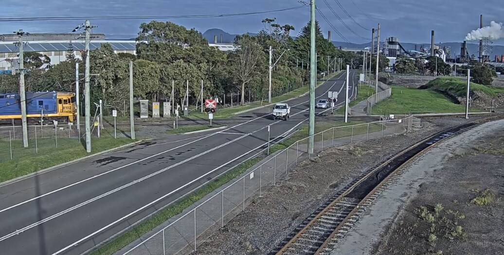 Danger: In a still from a video, a driver ignores the warning lights - and a freight train - and speeds over a level crossing. Picture: Transport for NSW