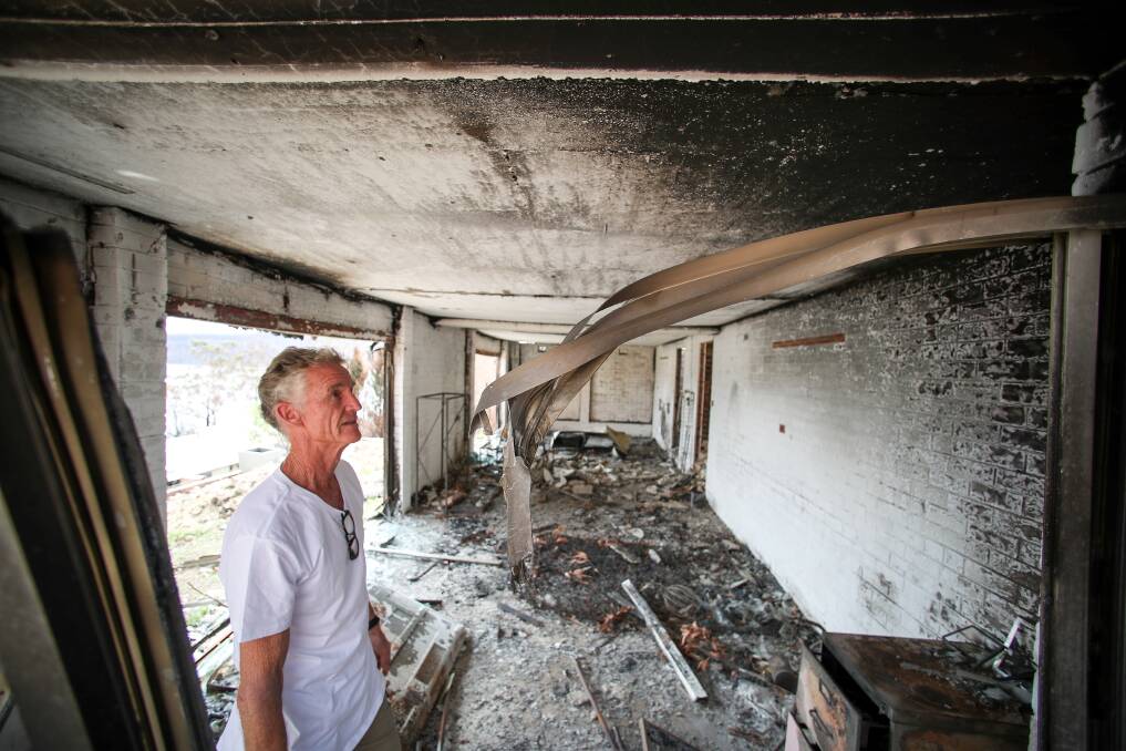 Lake Conjola resident Greg Webb inspects what was left of his home after the bushfires came through. Picture: Adam McLean