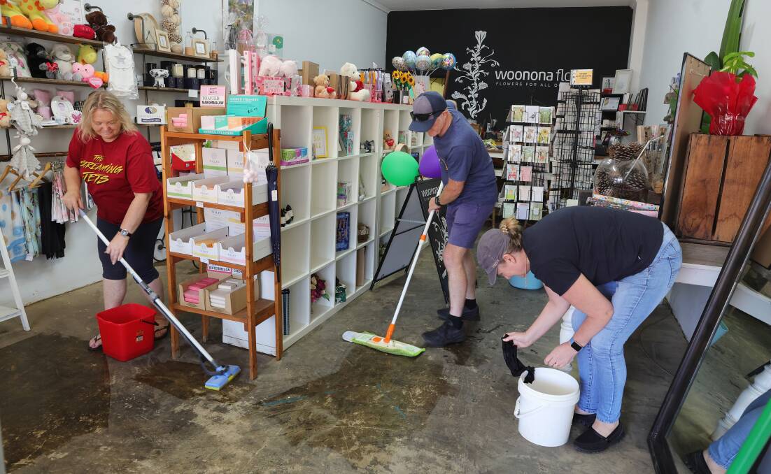 Penny Wilson and friends clean up her Woonona florist shop. She said locals were out in force to pitch in and help. Picture by Sylvia Liber