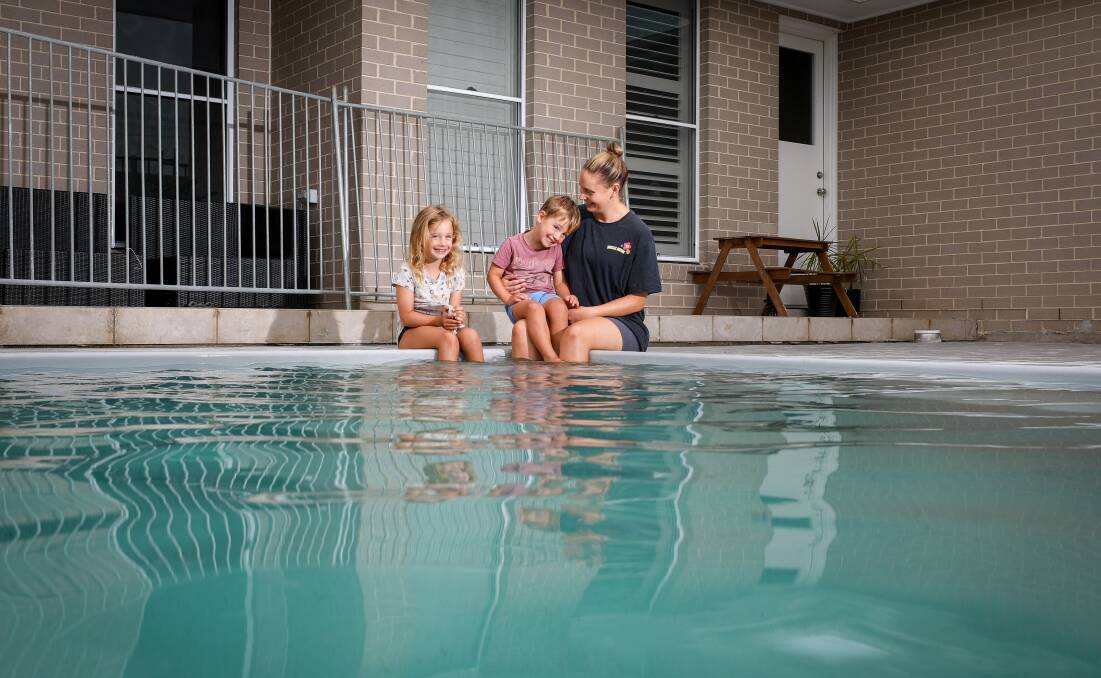 Alisha Stoddart, with children Charlotte and Ollie Manago, is one of many people in Wollongong who decided to have a pool built in their backyard, prompting long waiting lists. Picture by Adam McLean