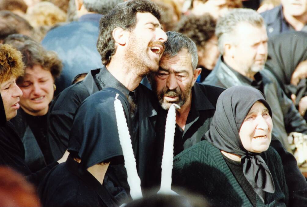 Ljube Velevski cries on the shoulder of his father Petre at the funeral for his family. He was later arrested with their murders - he will walk free from prison on Thursday.