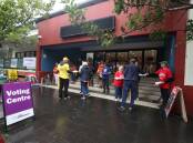 Early start: Party candidates and volunteers handing out how to votes in Wollongong on the first day of pre-poll voting. Picture: Robert Peet