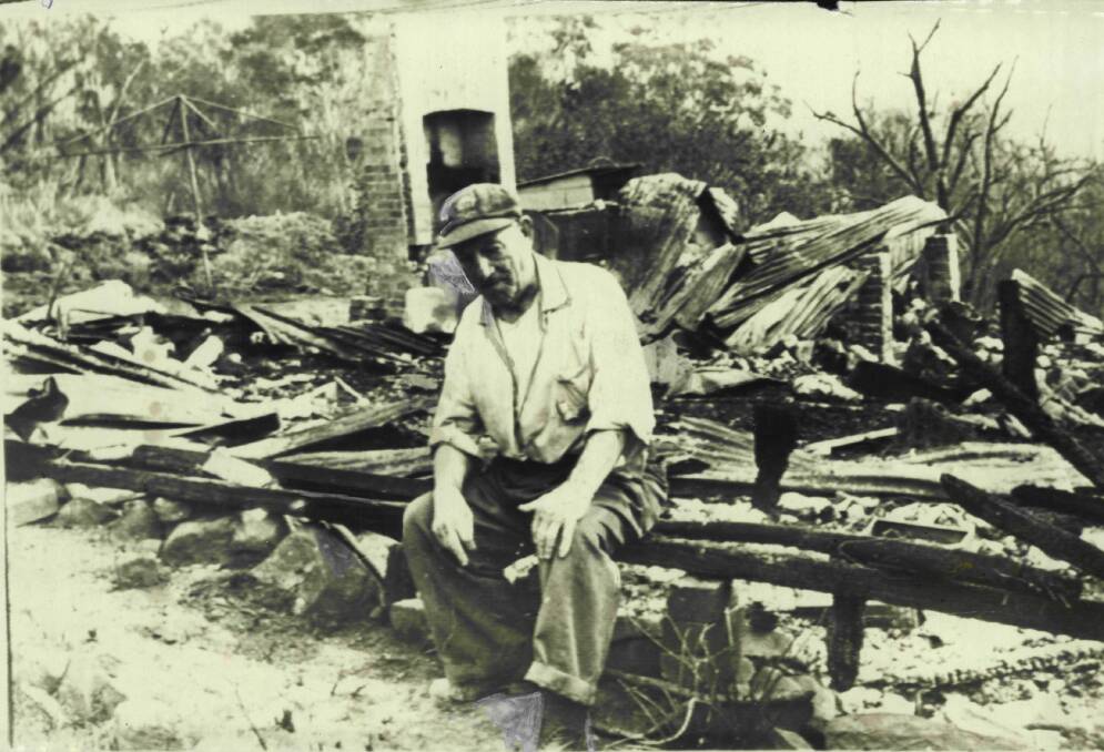 George Coulton sits amid the ashes of his uninsured Bulli Pass home.