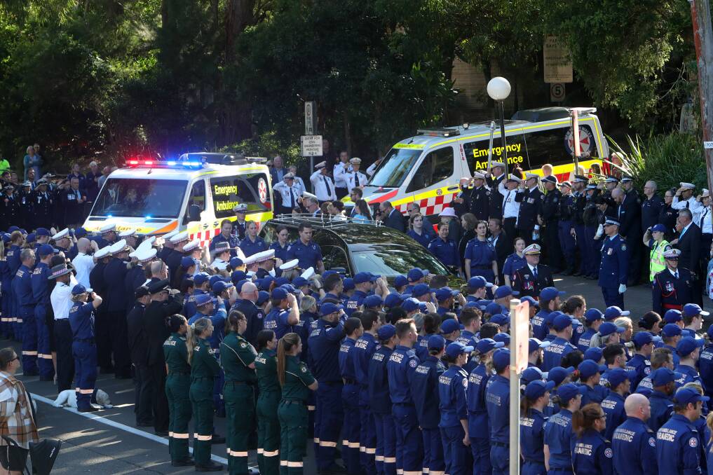 Emergency services personnel form a guard of honour at Steven Tougher's funeral earlier this month. The paramedic has been praised on the floor of parliament. Picture by Glen Humphries