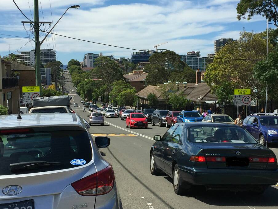 School run: A line of cars effectively parked in the middle of the lane outside Wollongong Public School while picking up their children on Monday afternoon.