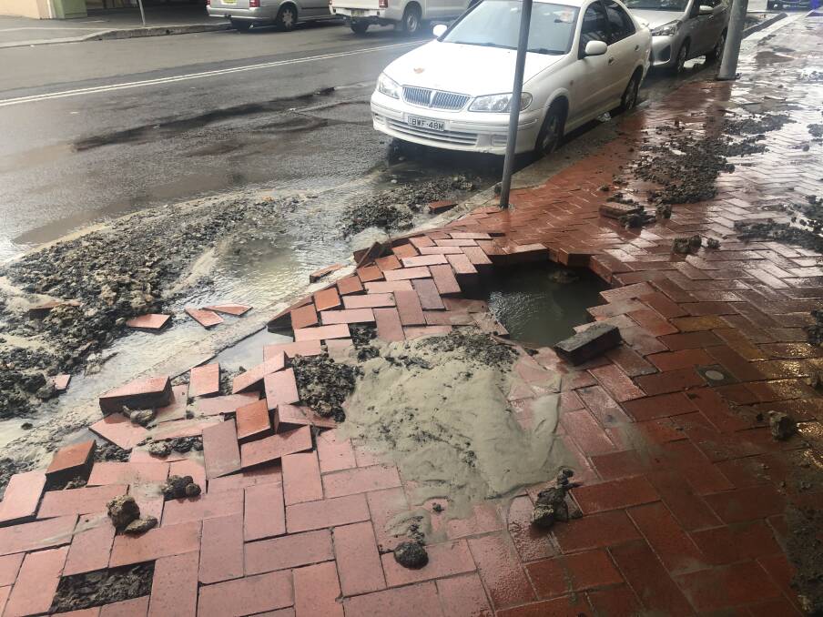 The hole in the footpath of lower Crown Street after a water main burst around 6pm. Picture: Fire and Rescue NSW